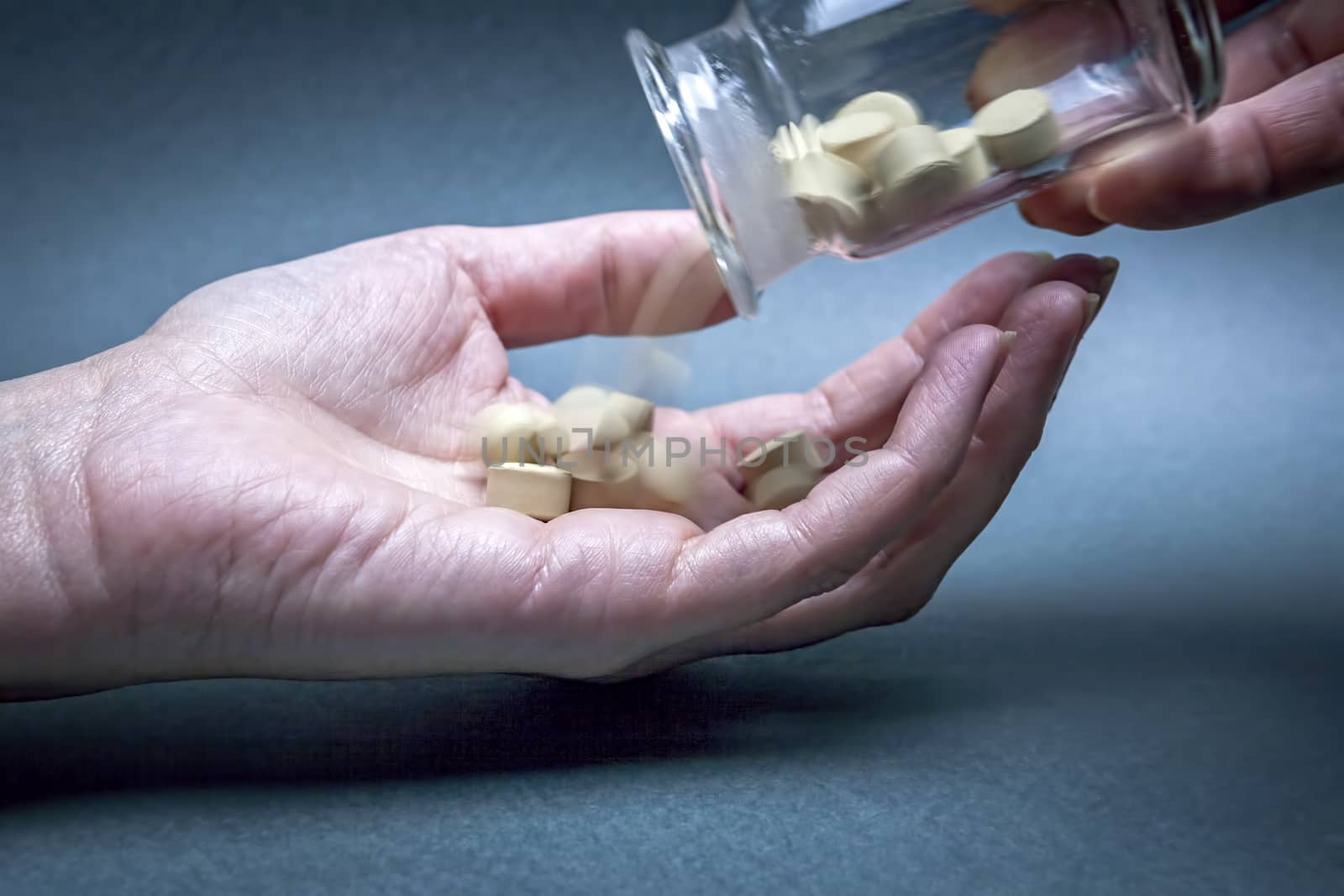 Closeup on woman's hands with pills and pill container transparent