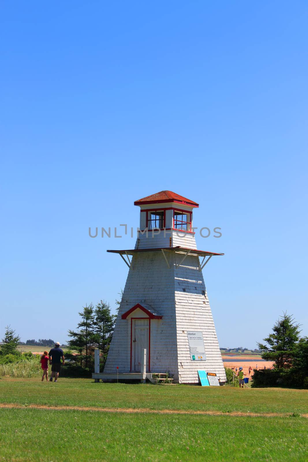 Lighthouse at Cabot Beach with beachgoers in Prince Edward Island, Canada