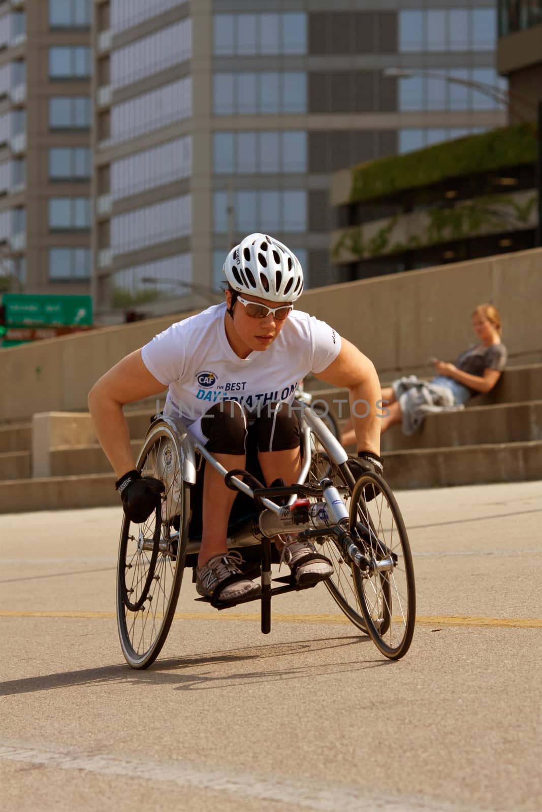 CHICAGO, IL - MAY 26, 2012:  An unidentified female in a racing wheelchair works out on an asphalt recreational area that runs alongside Chicago's famous Lakeshore Drive.  The warm weather brought many locals and tourists outside to enjoy the long Memorial Day weekend and to kickoff summer.