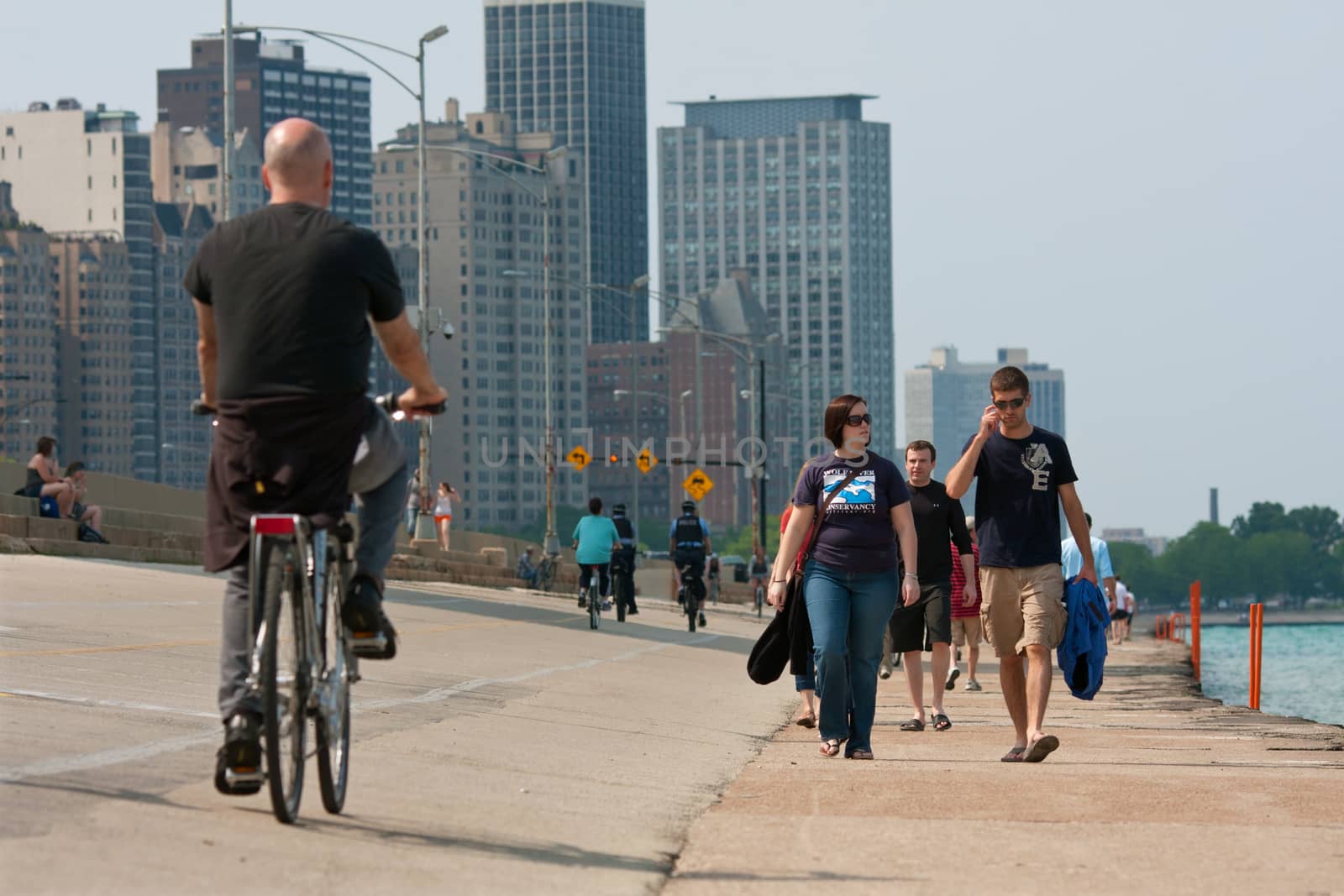 CHICAGO, IL - MAY 26, 2012:  Pedestrians and people on bicycles enjoy being outdoors along the Lake Michigan shoreline, just off Chicago's famous Lakeshore Drive.  The warm temperatures and Memorial Day holiday weekend brought thousands of people outdoors.