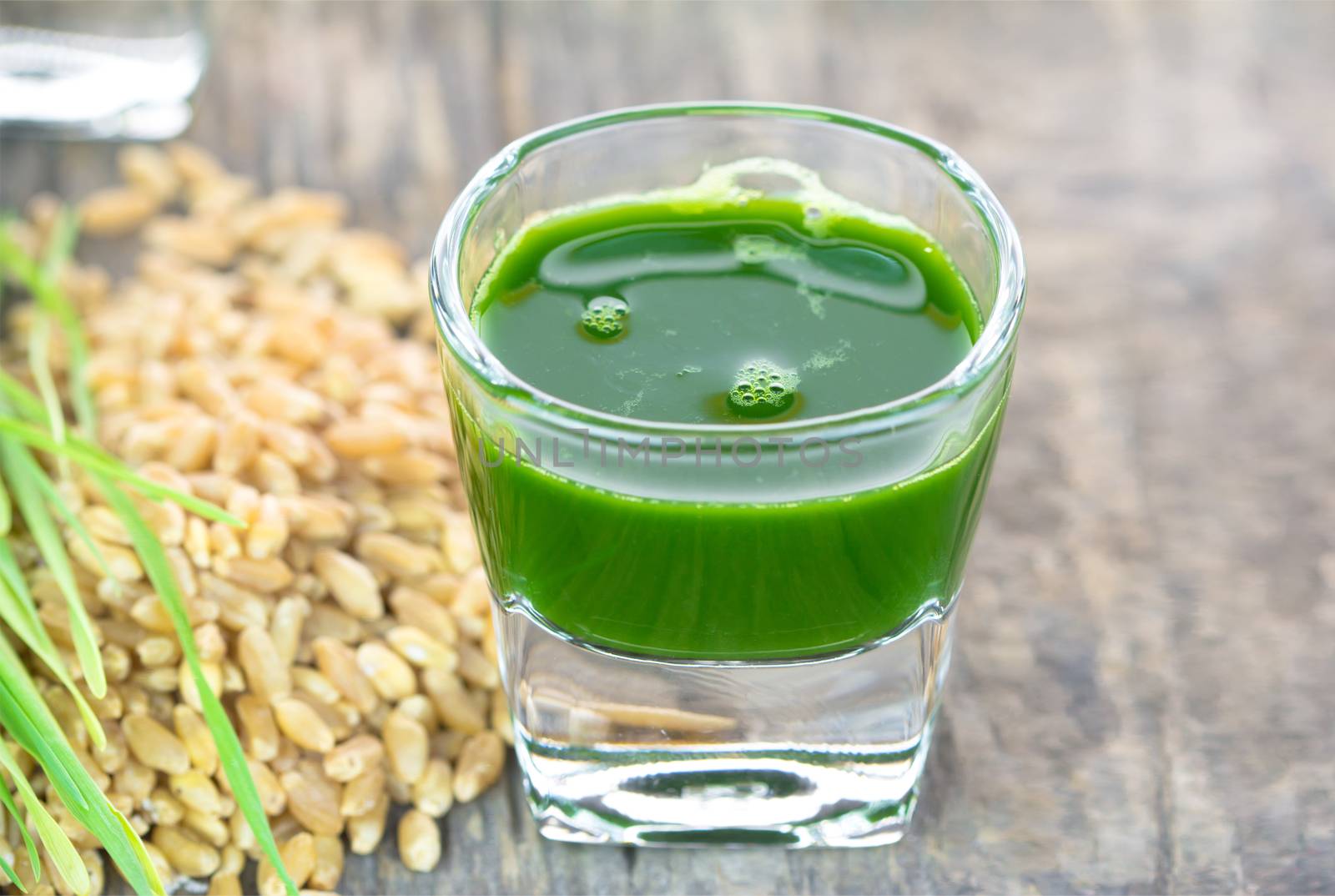 Wheat grass juice on wood background by wyoosumran