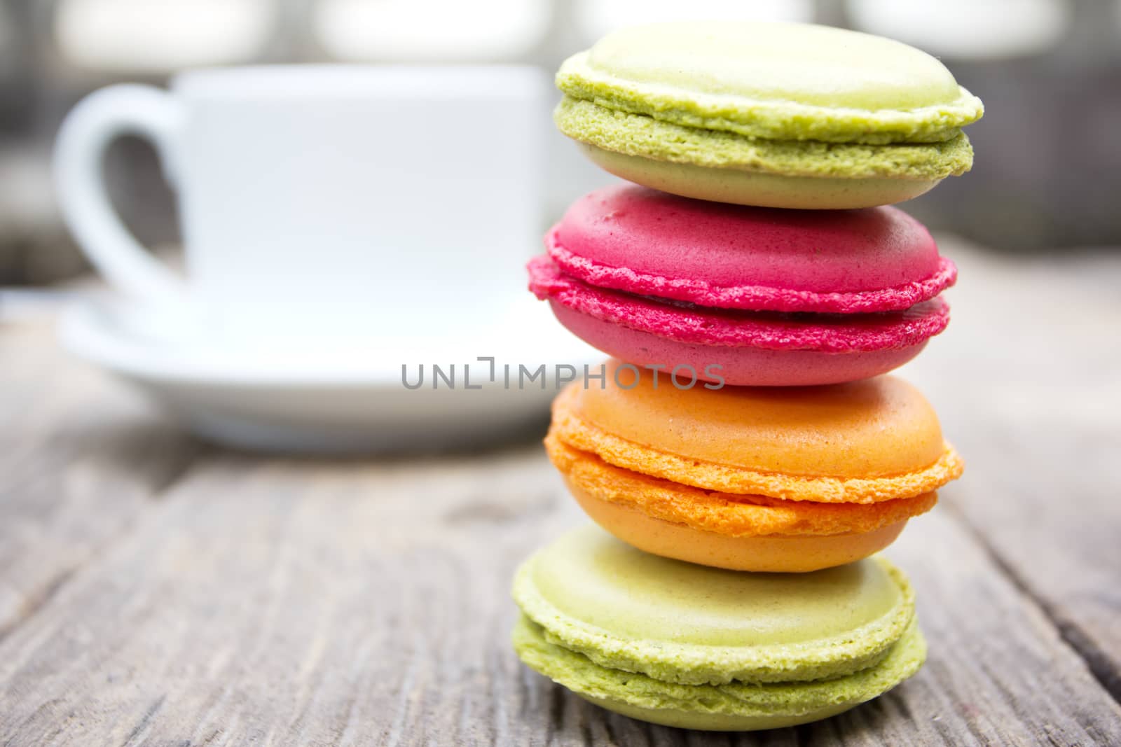 Macaroons on a wooden table with cup of coffee