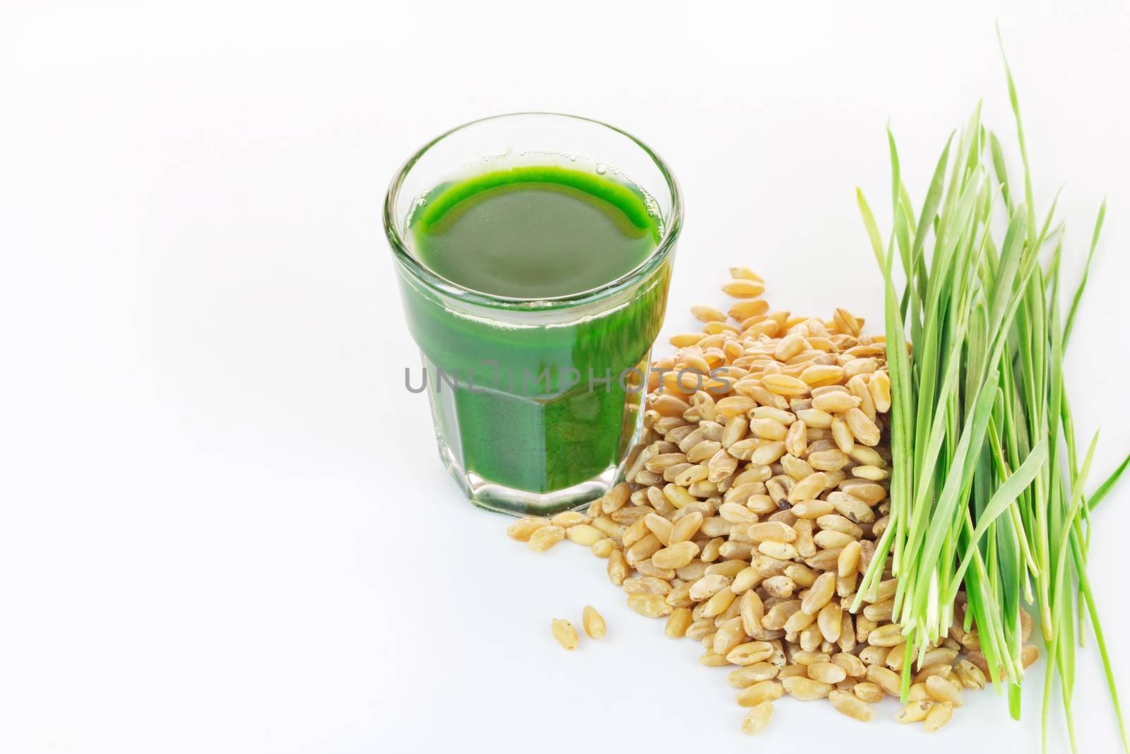 Wheat grass juice on white background  by wyoosumran