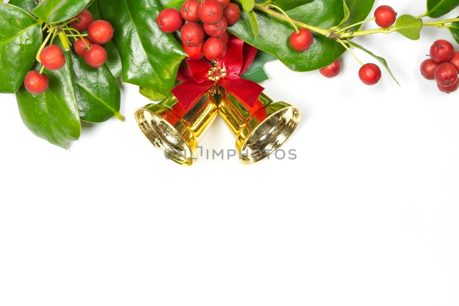 Holly Christmas decoration, and golden bell on white