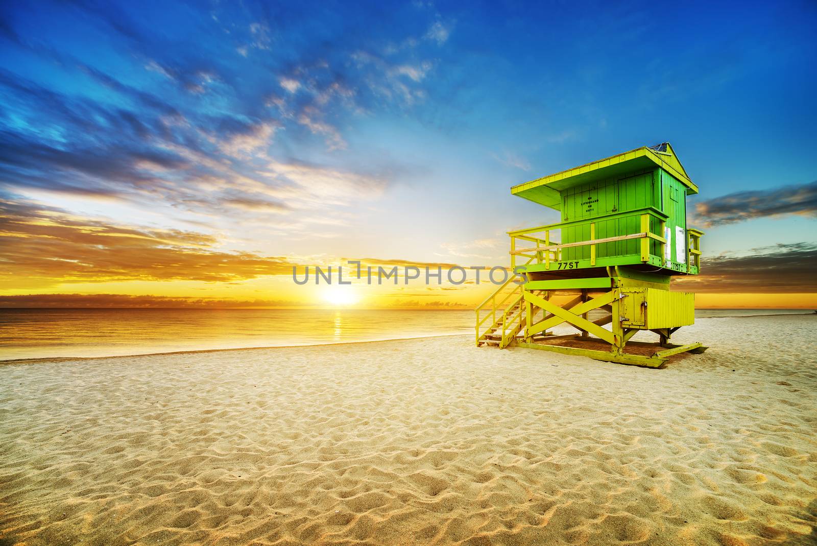 Miami South Beach sunrise with lifeguard tower and coastline with colorful cloud and blue sky. 