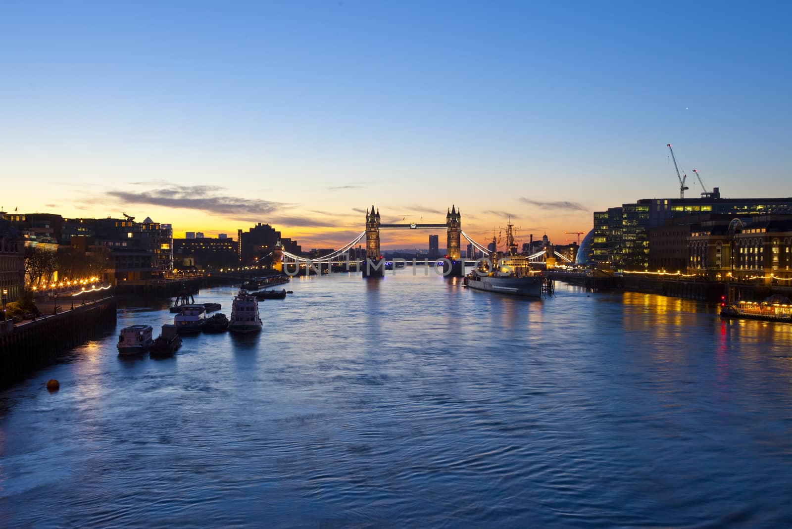 London sunrise with Tower Bridge, City Hall, HMS Belfast and the River Thames in the foreground.