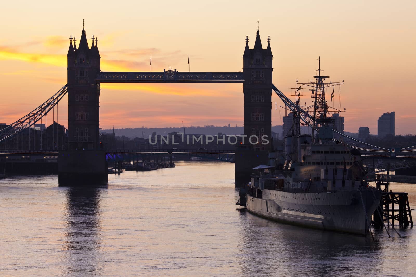 The beautiful sunrise behind Tower Bridge and the HMS Belfast in London.