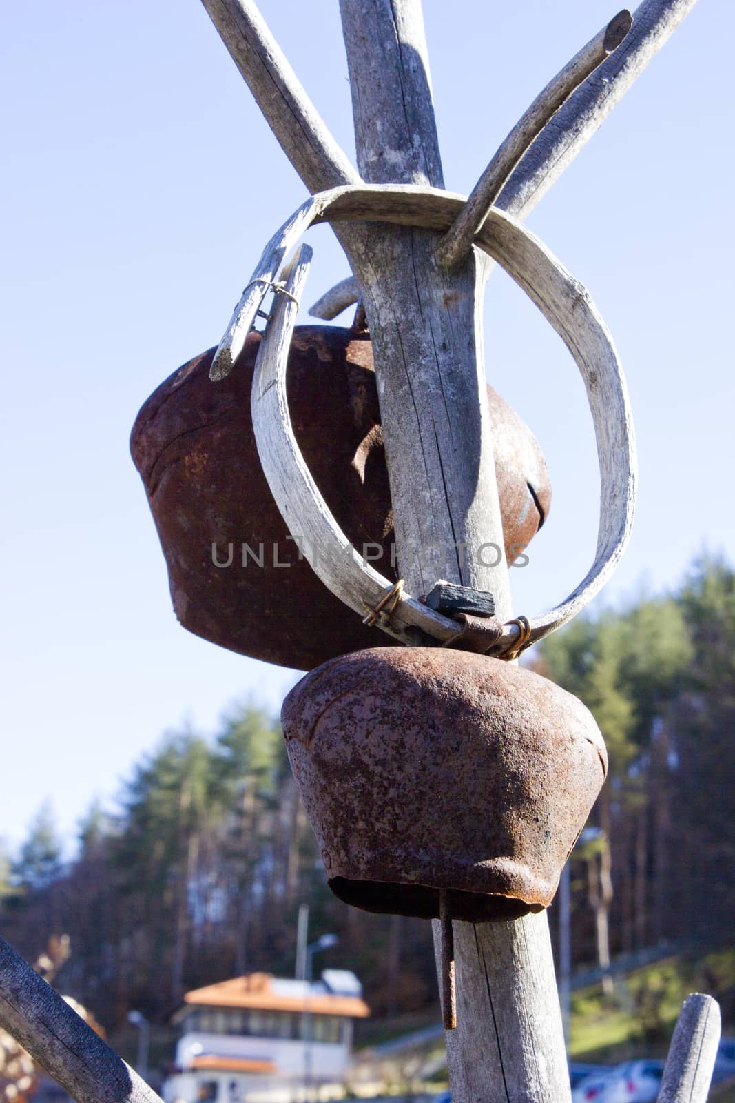 Cow bells hung from a wooden pole. Picture taken in a old village yard.