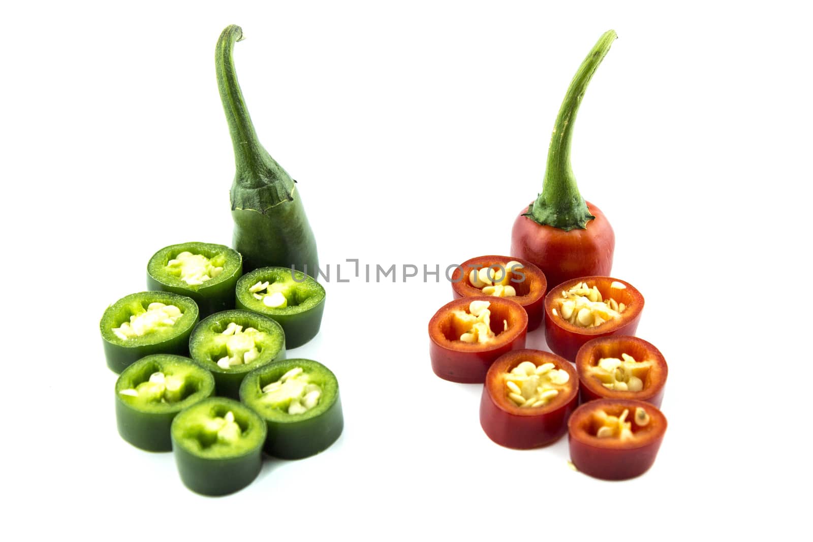 red and green hot chili pepper slices on a white background