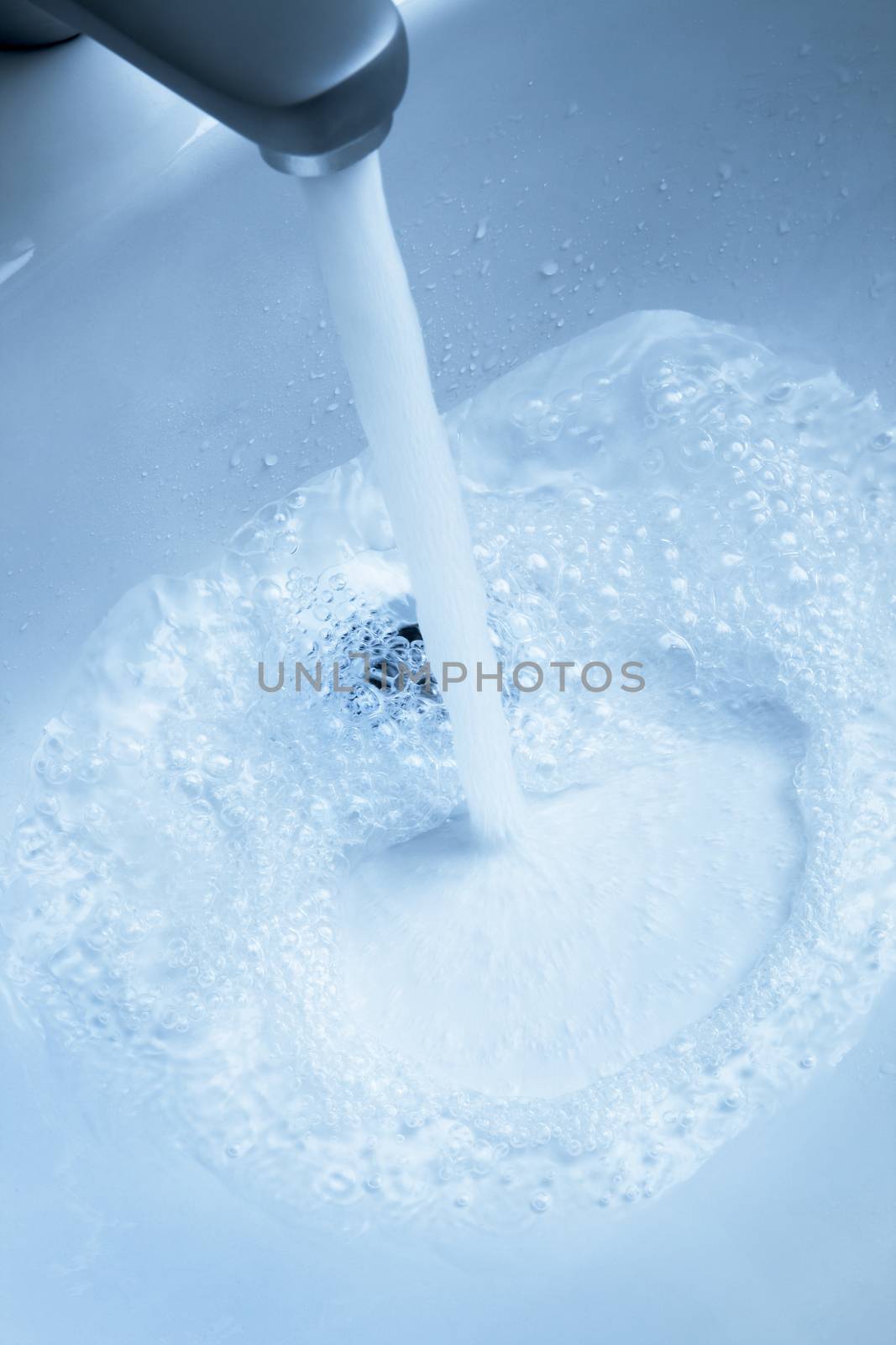 Stream and drops of pure water in a sink