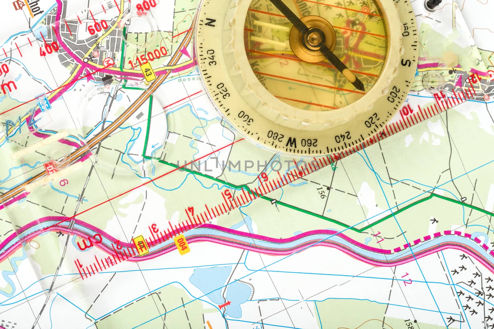 old touristic handheld compass on detailed territory map 