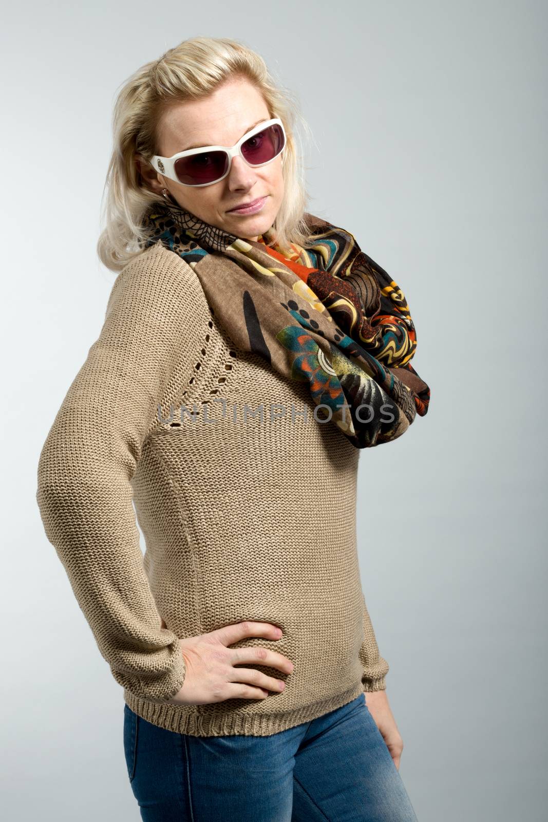 close up studio portrait of beautiful woman with sweater, scarf and sun glasses