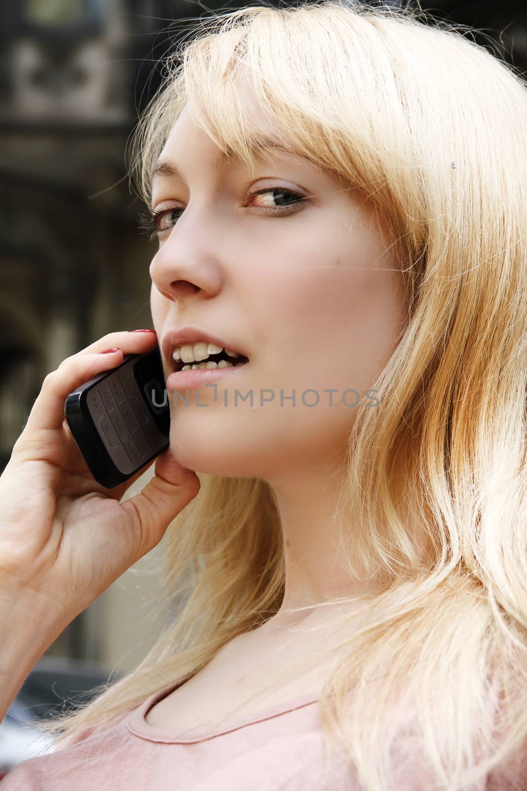 A young adult woman talking on the phone.