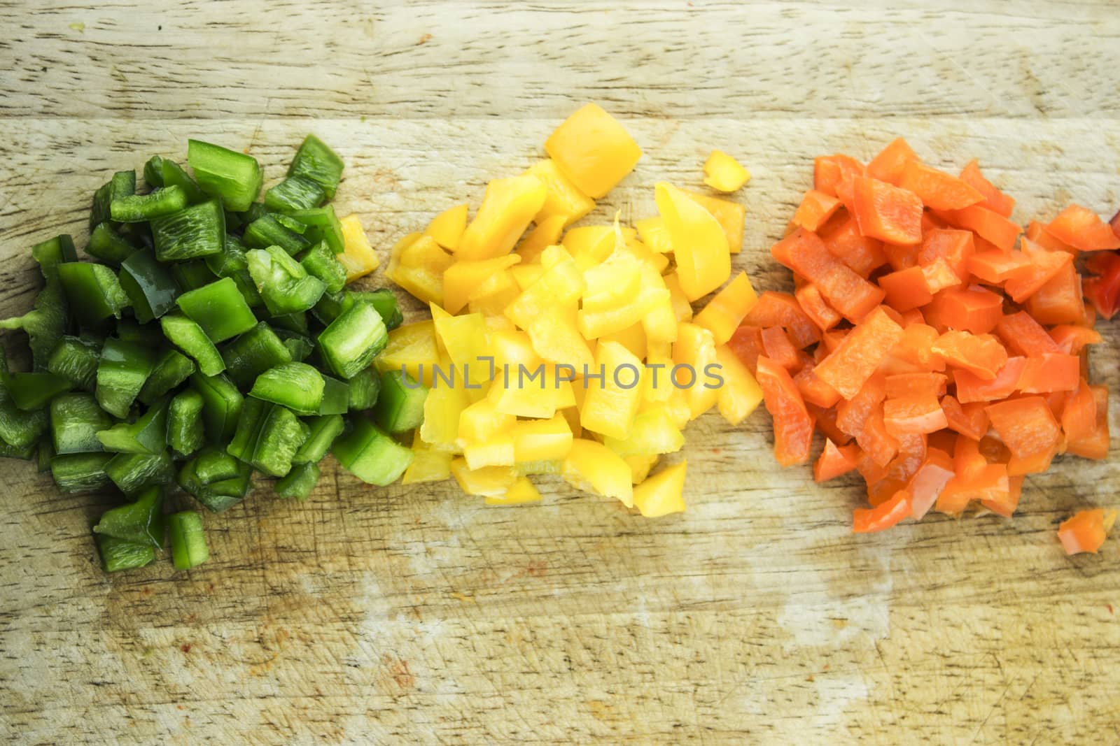 slices of colorful sweet bell pepper on wood board.