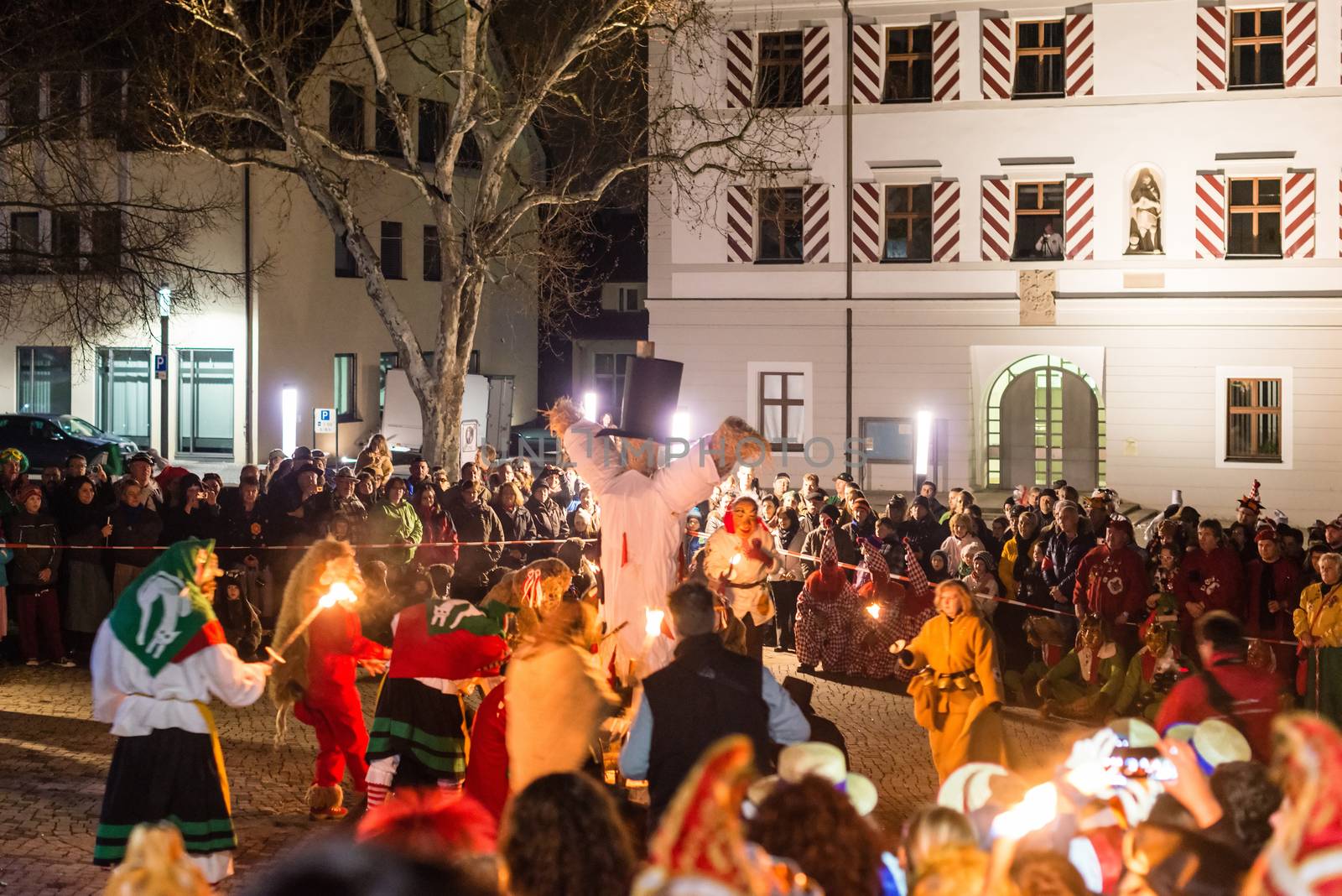 NEUHAUSEN, GERMANY ��� MARCH 4, 2014: Masked people are celebrating the end of carnival (fasnet) season by burning a puppet that is wearing a traditional costume (called the ���H��s���) symbolizing carnival on March 4, 2014 in Neuhausen (near Stuttgart), Germany. Carnival has a very long tradition in Neuhausen with influences of the swabian alemanisch culture that can be seen by the wooden masks people are wearing as part of their costumes.