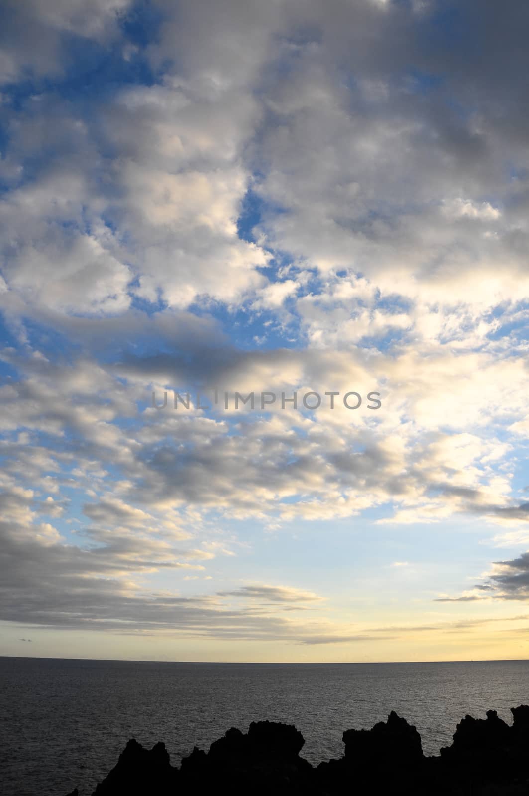 Some Colored Clouds over the Ocean on a Blue Sky