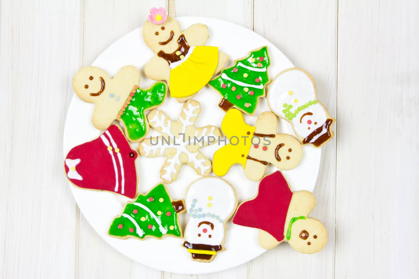 Cookies decorated with a Christmas theme , on white dish over wood background