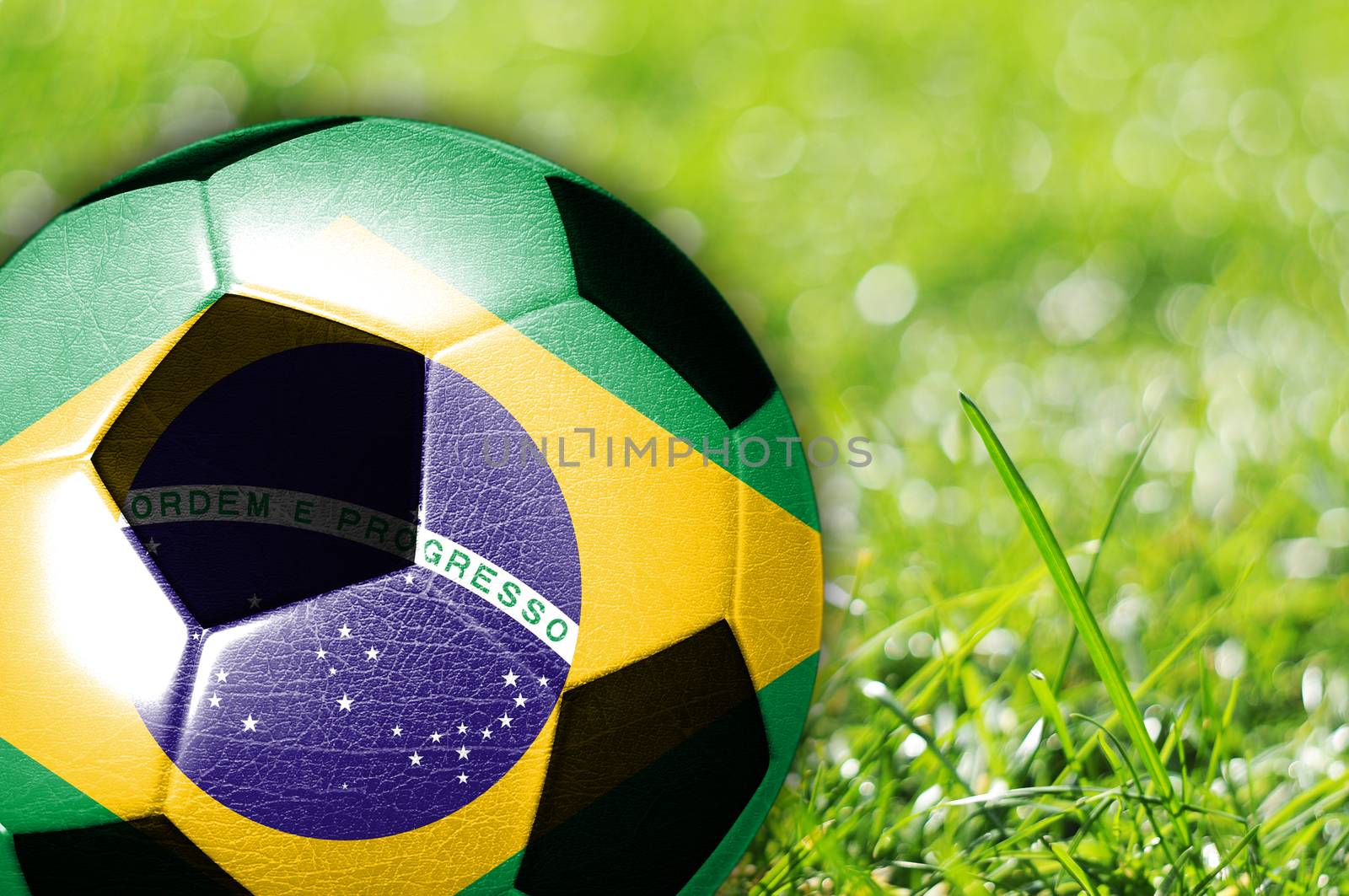 Soccer ball on grass with flag of Brazil painted on it