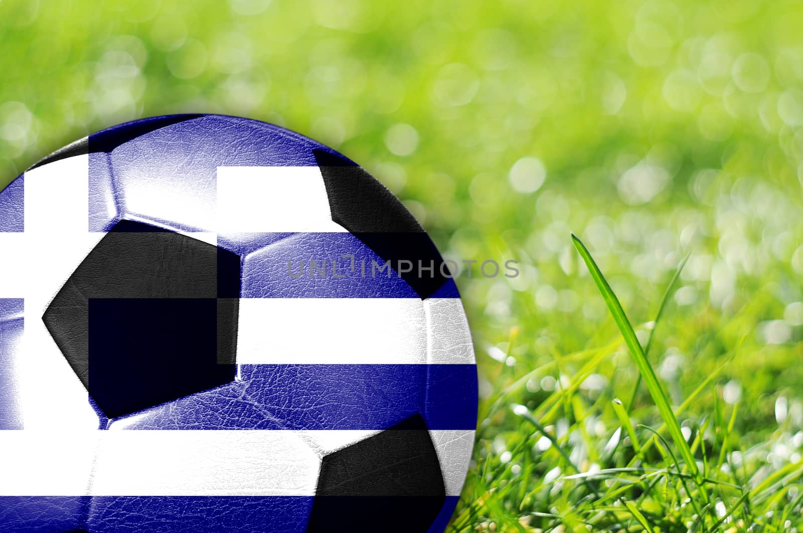 Soccer ball on grass with flag of Greece painted on it