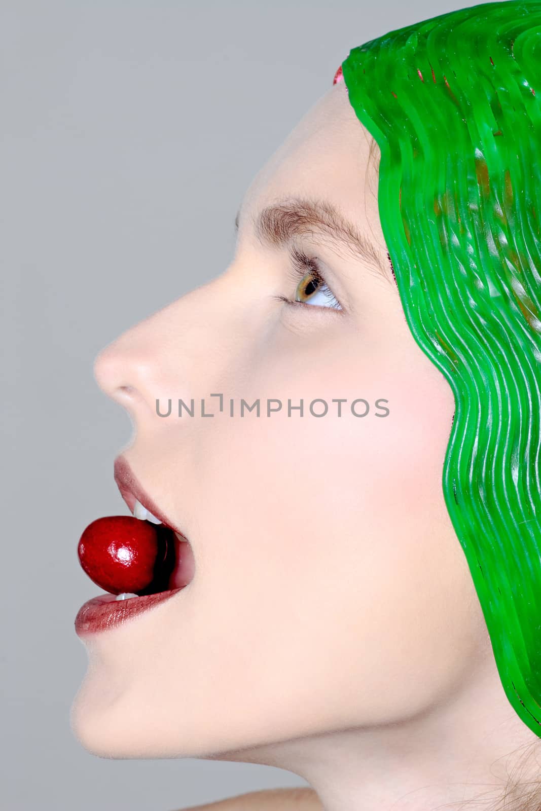 beauty portrait of a young caucasian woman biting eating cherry