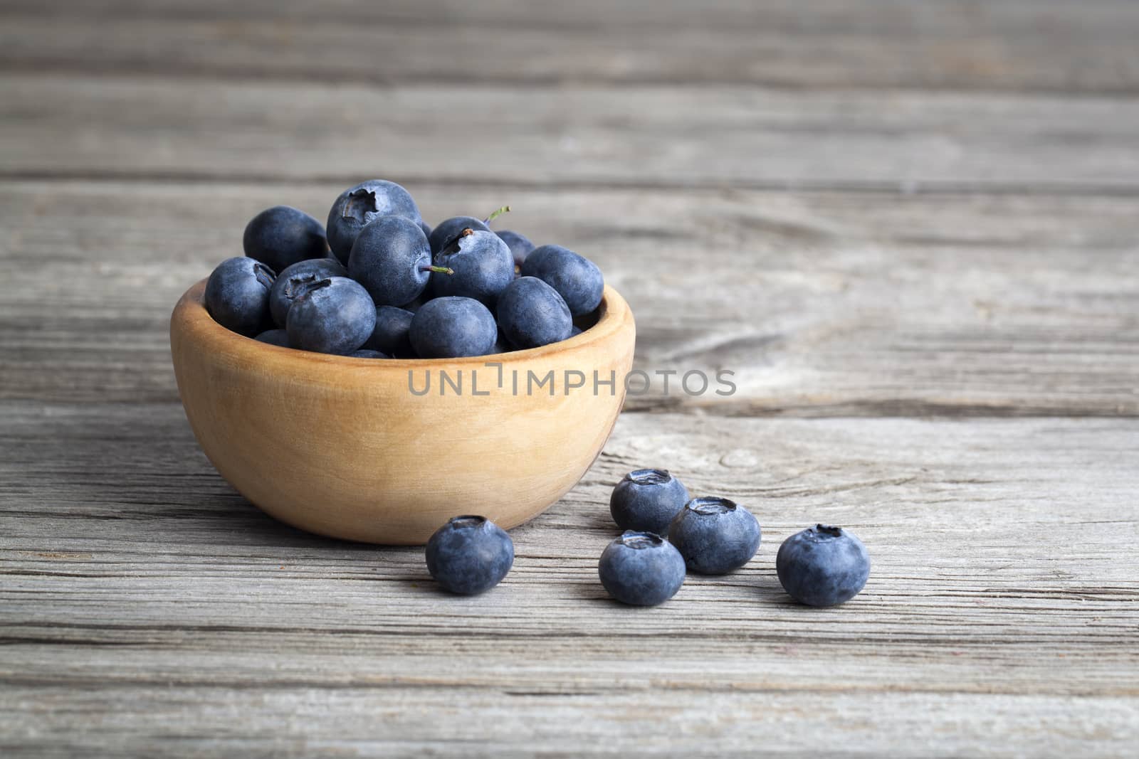 bowl of blueberries on wooden background