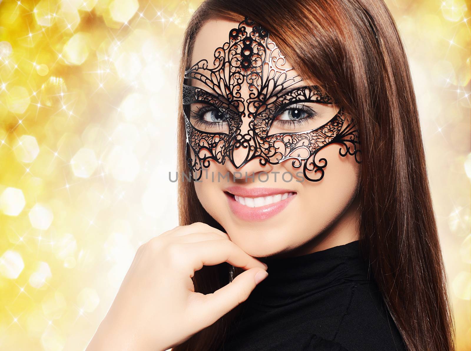 Beautiful woman in carnival mask over yellow background