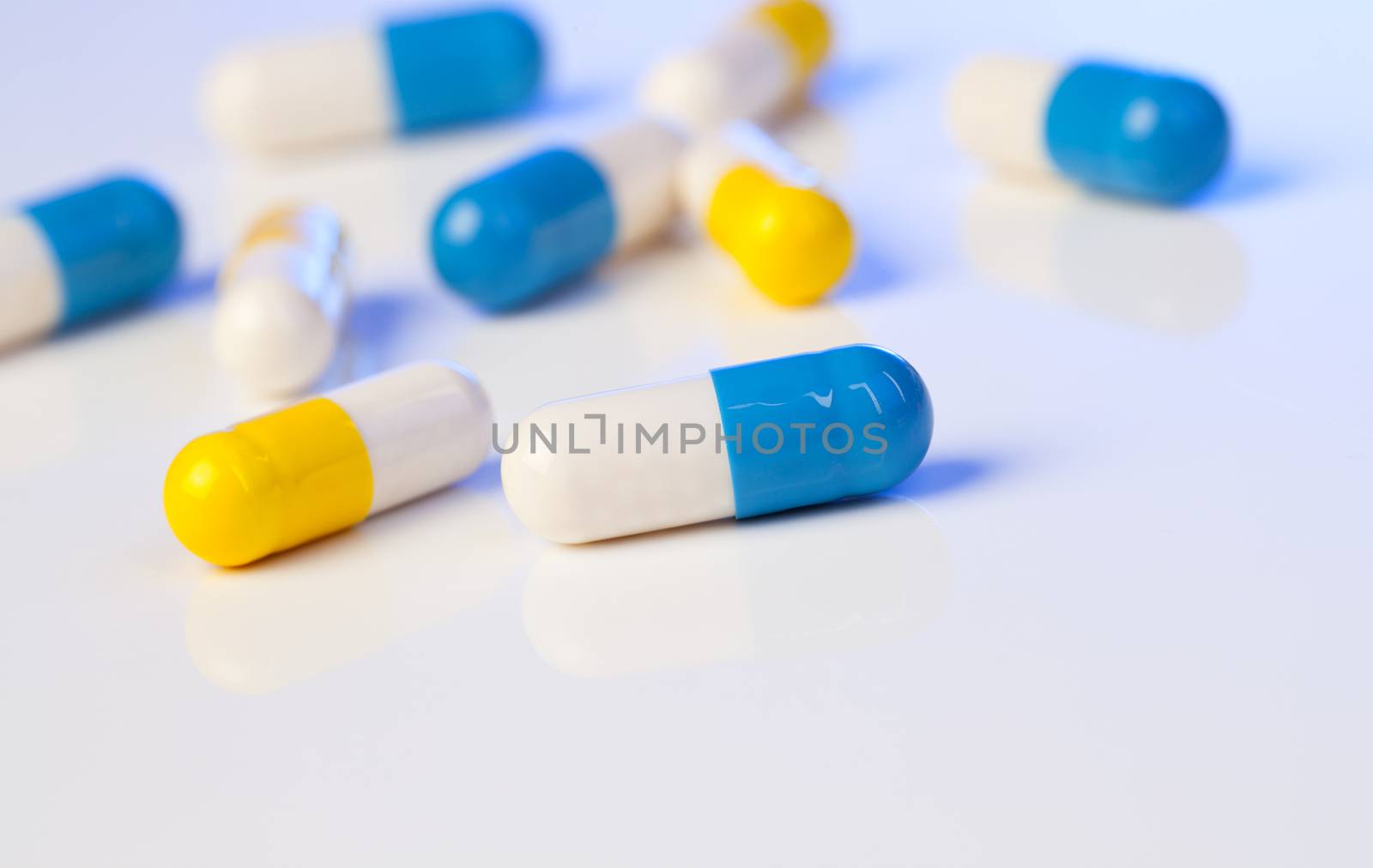 Colorful medical capsules on white background.