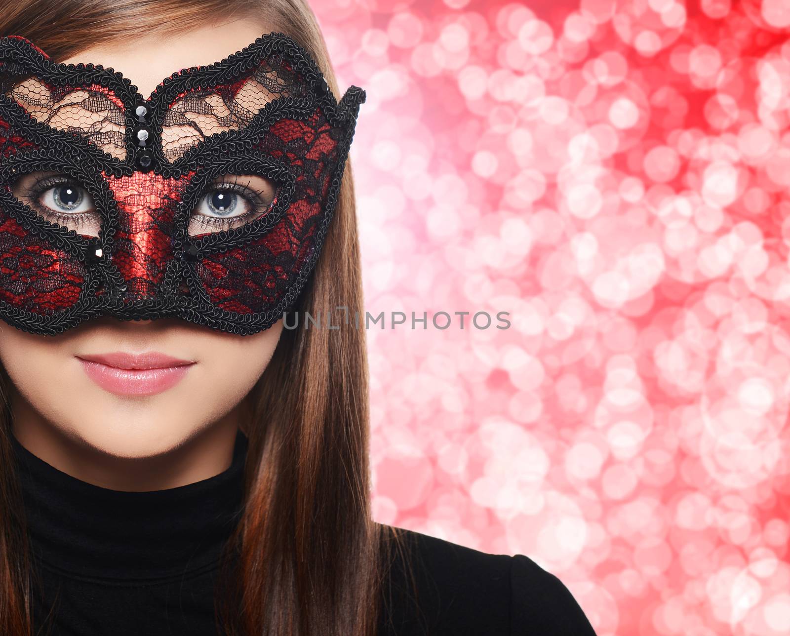 Beautiful woman in carnival mask over red bokeh background