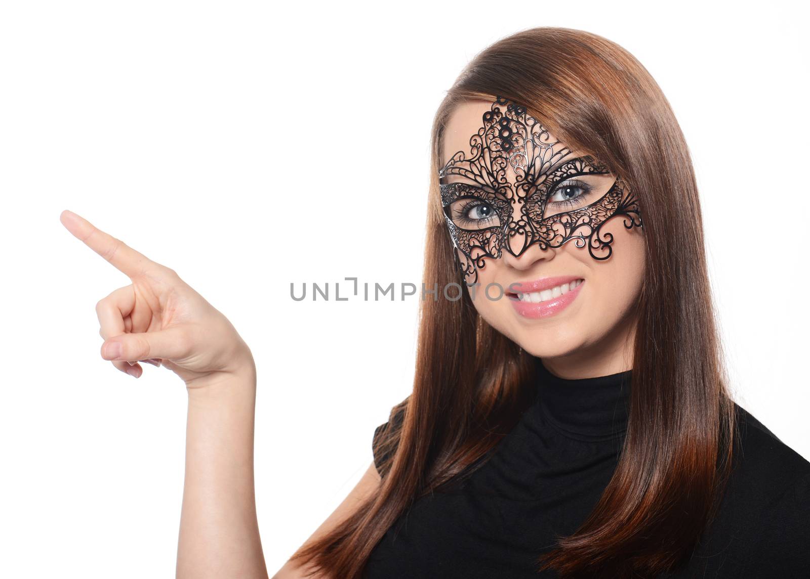 Beautiful woman in carnival mask pointing over white background