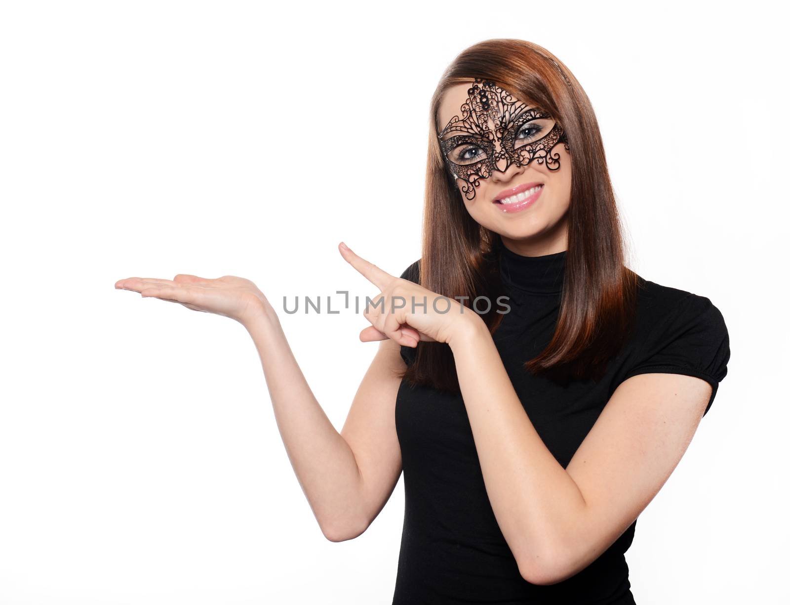 Beautiful woman in carnival mask pointing over white background