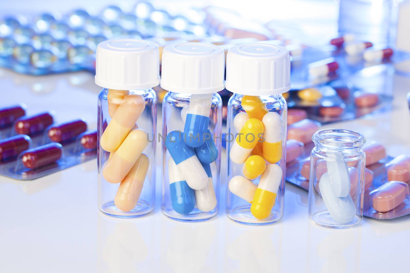 Colorful medical capsules in bottle, on white background.