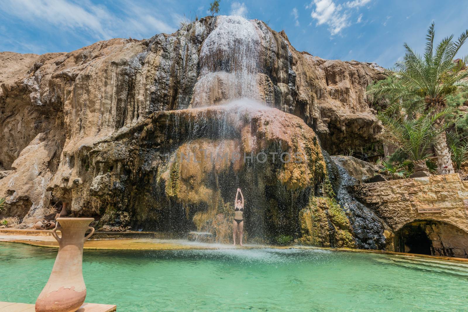 one woman bathing at ma'in hot springs waterfall in jordan middle east