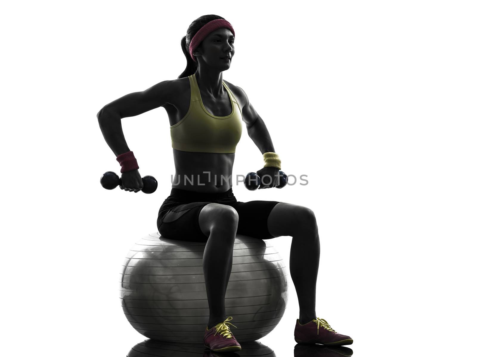 one woman exercising weight training on fitness ball in silhouette on white background