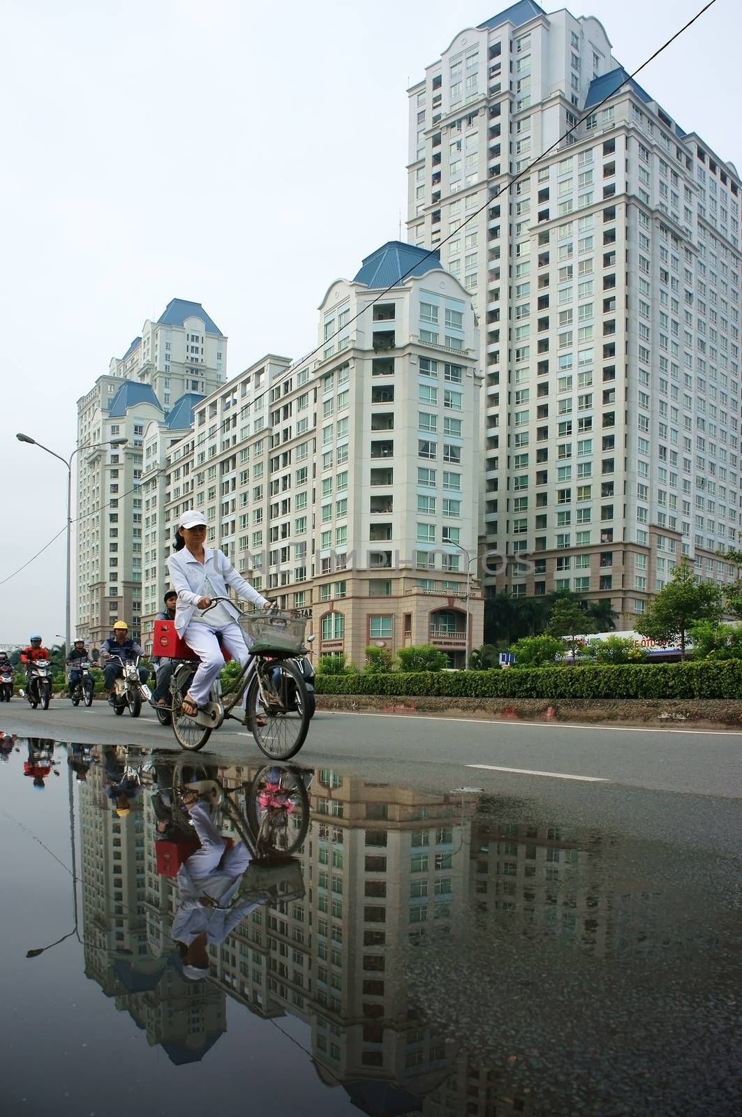 People ride bicycle with high-rise building background by xuanhuongho