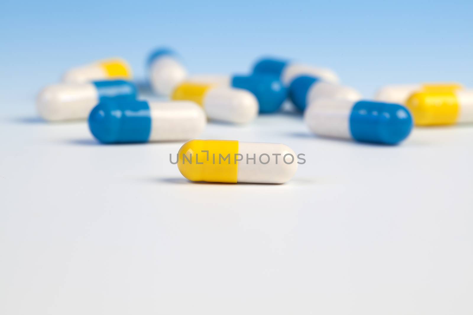 Colorful medical capsules on white background.
