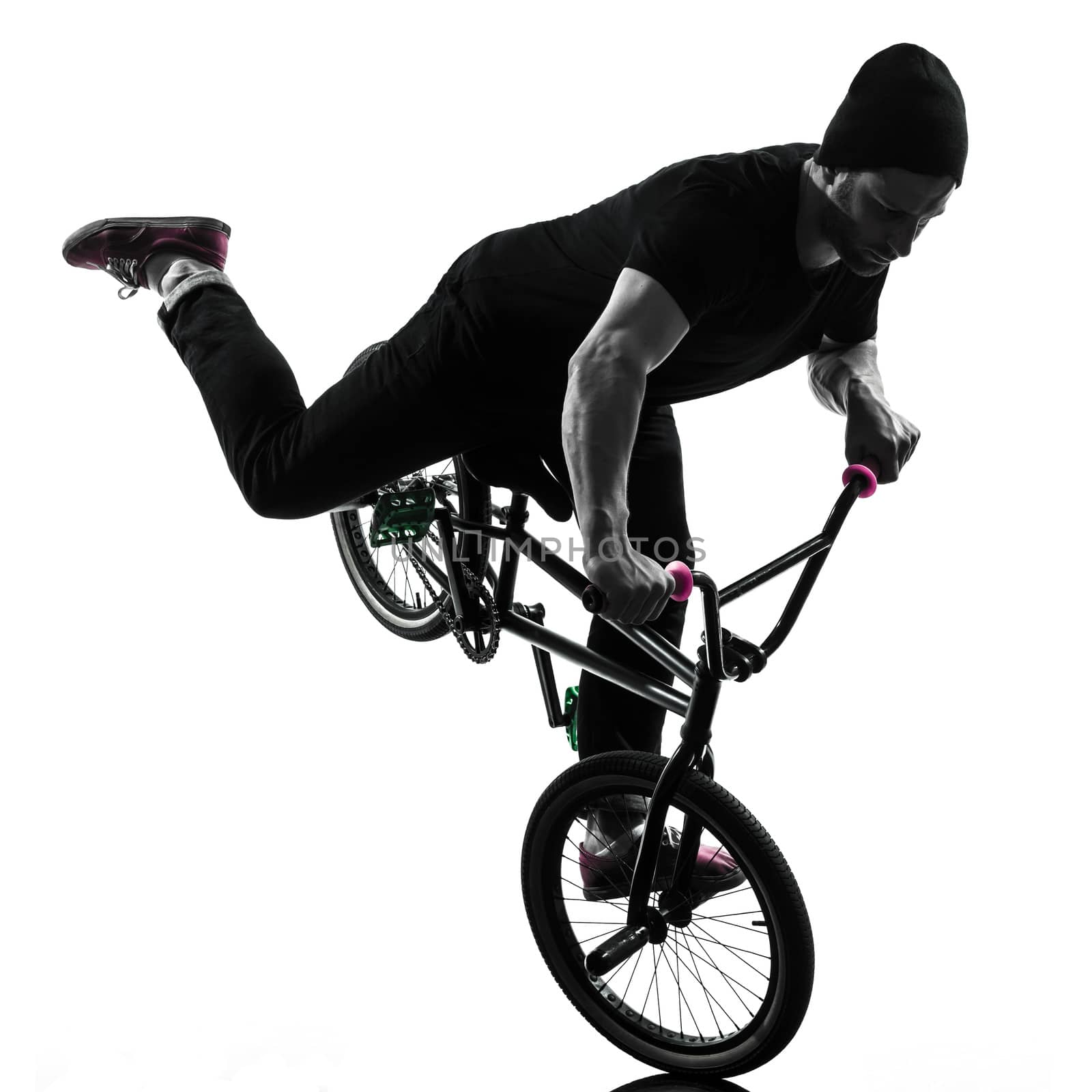 one caucasian man exercising bmx acrobatic figure in silhouette studio isolated on white background