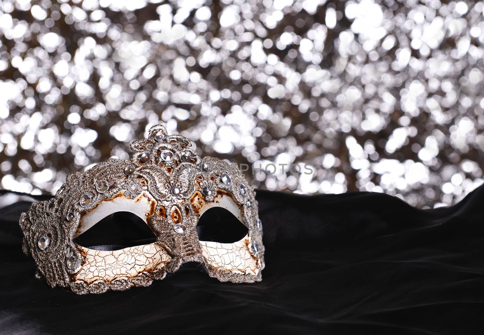 Silver carnival mask on bokeh background