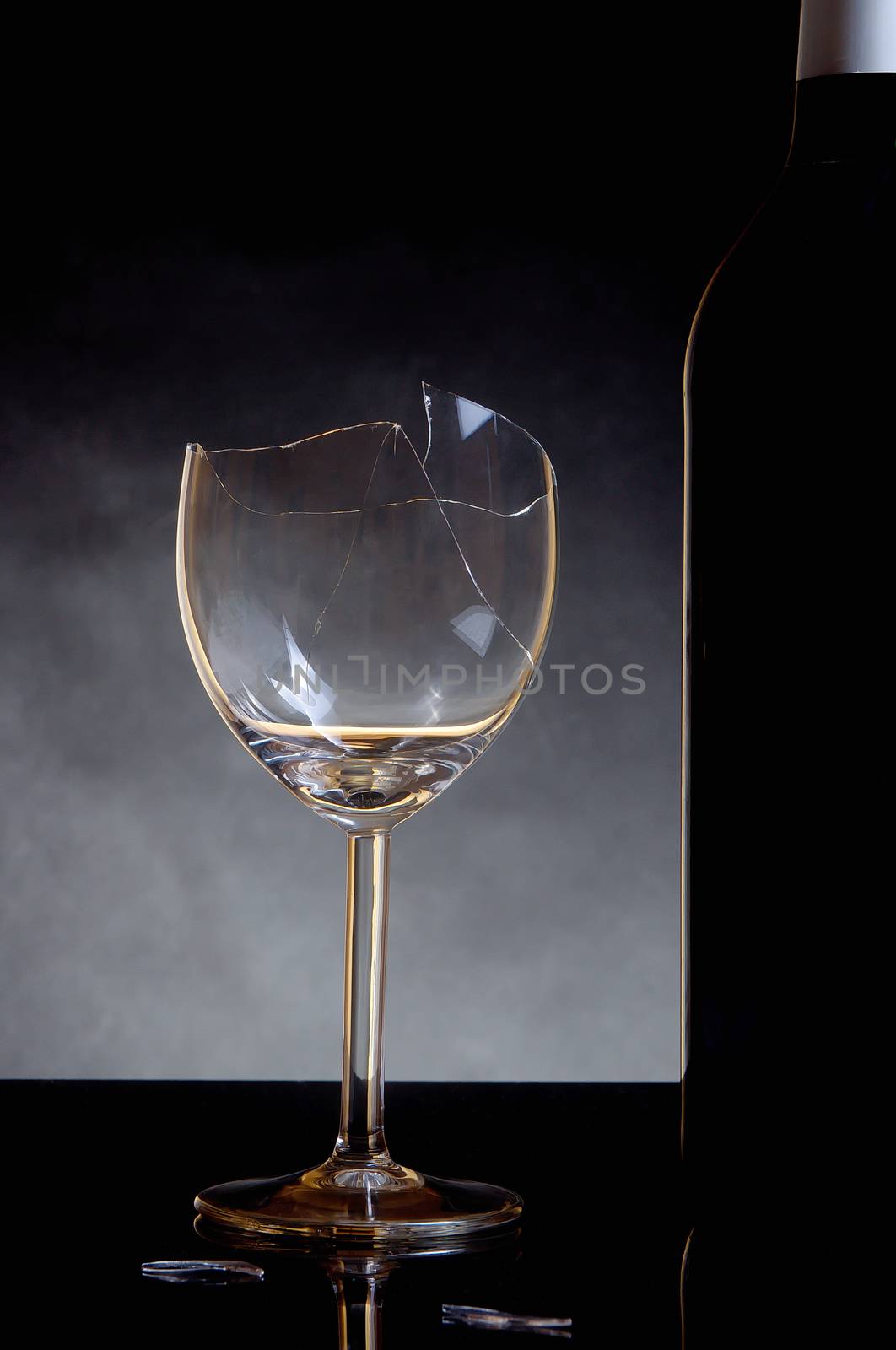 Vine bottle and broken glass on dark background by anderm
