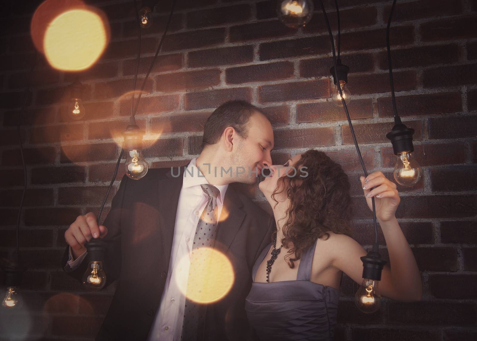 loving couple in the background of walls from a brick and light bulbs