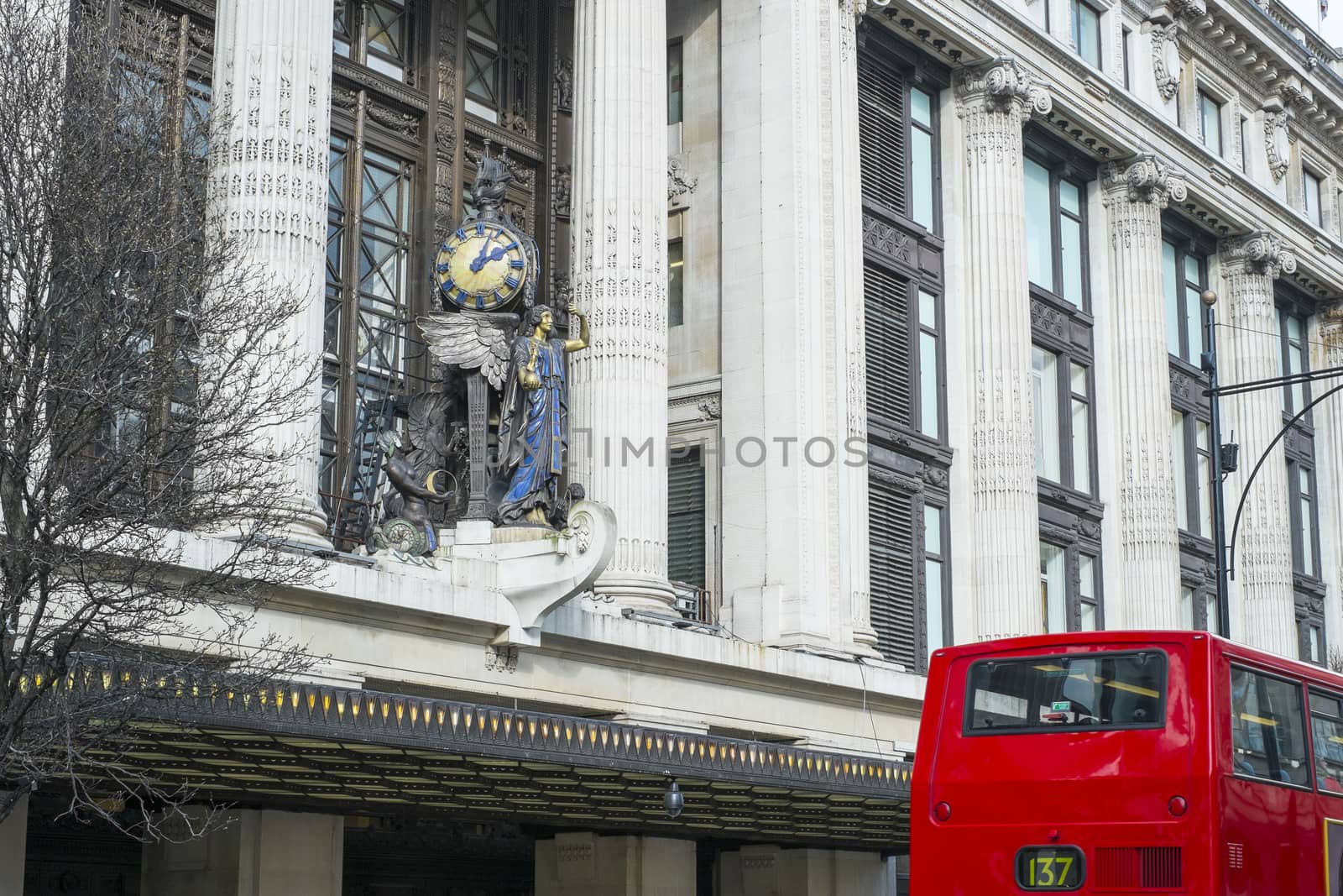 LONDON, UK - MARCH 14: Facade of famous department store Selfridges, with statue of angel holding clock. March 01, 2014 in London.