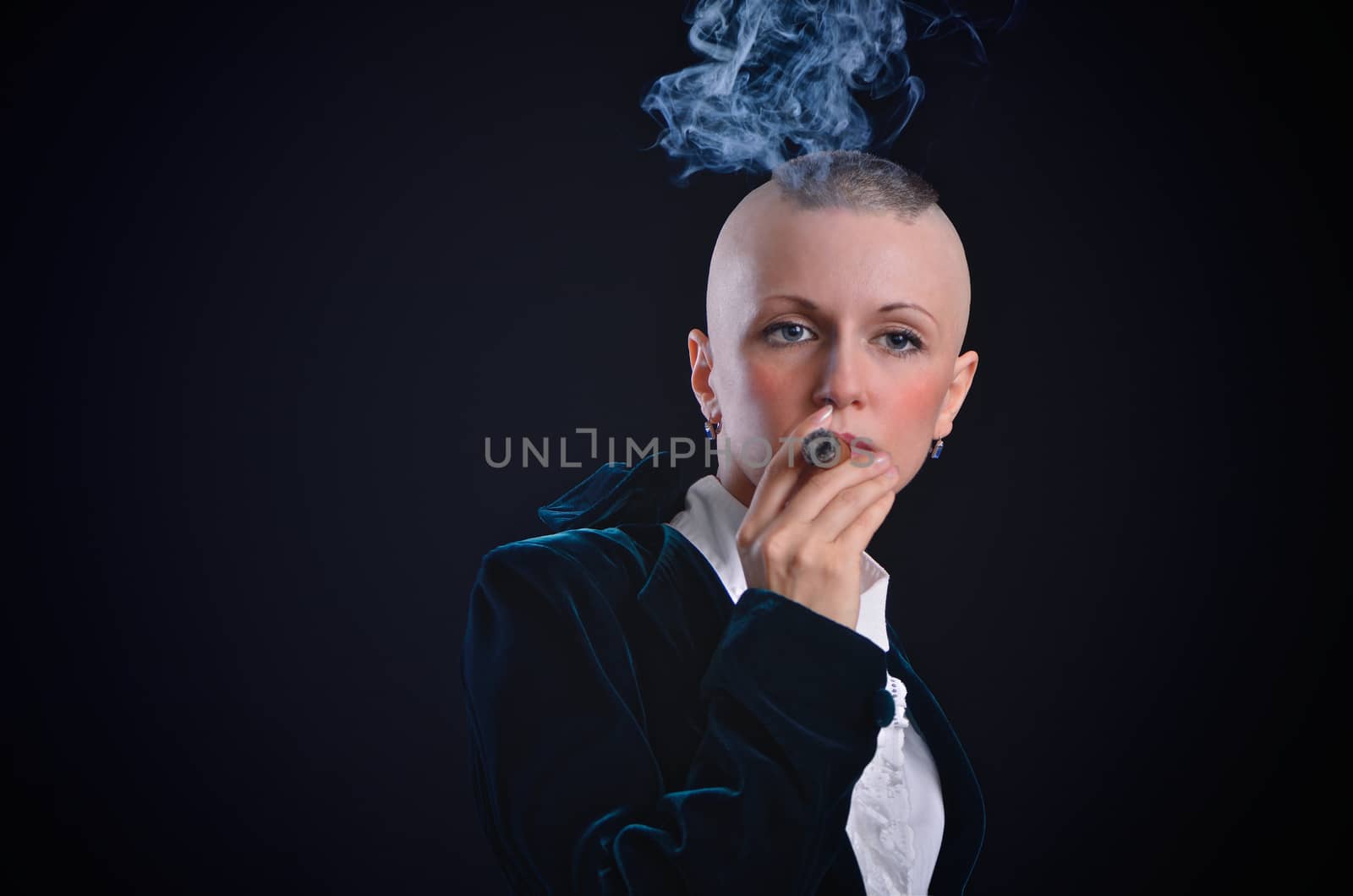 Bald young woman smoking cigar in studio