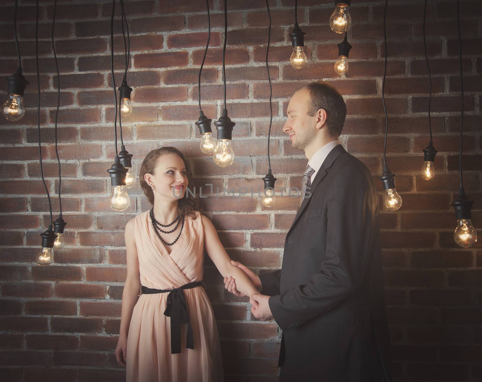 loving couple in the background of walls from a brick and light bulbs