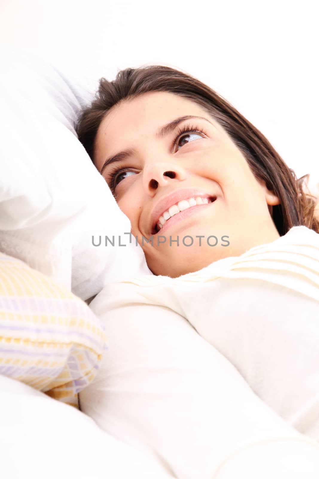 A young girl laying in bed and smiling

