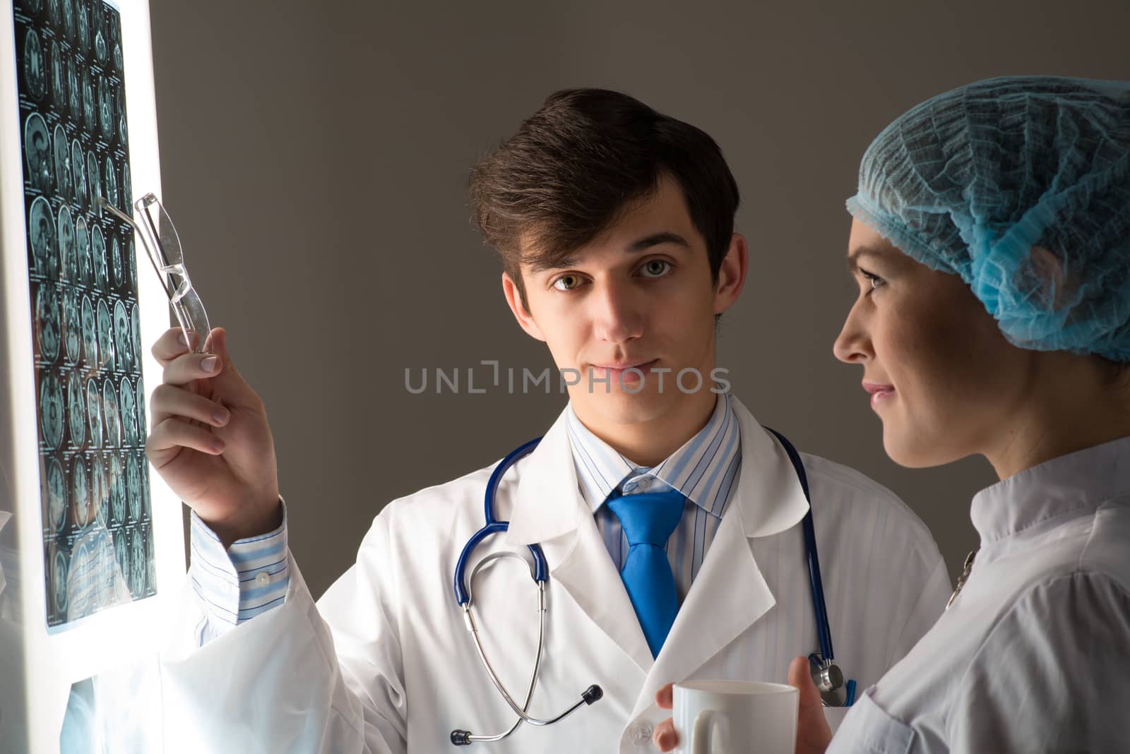 medical colleagues confer near the x-ray image fixed on the glowing screen