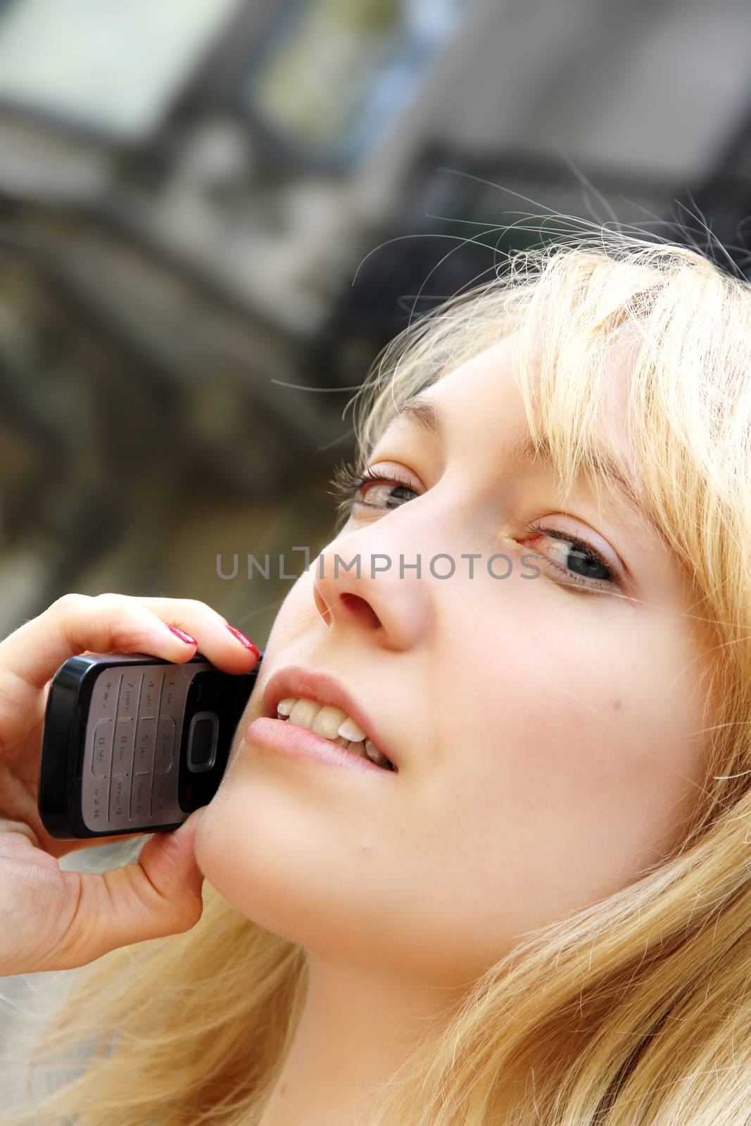 A young adult woman talking on the phone.