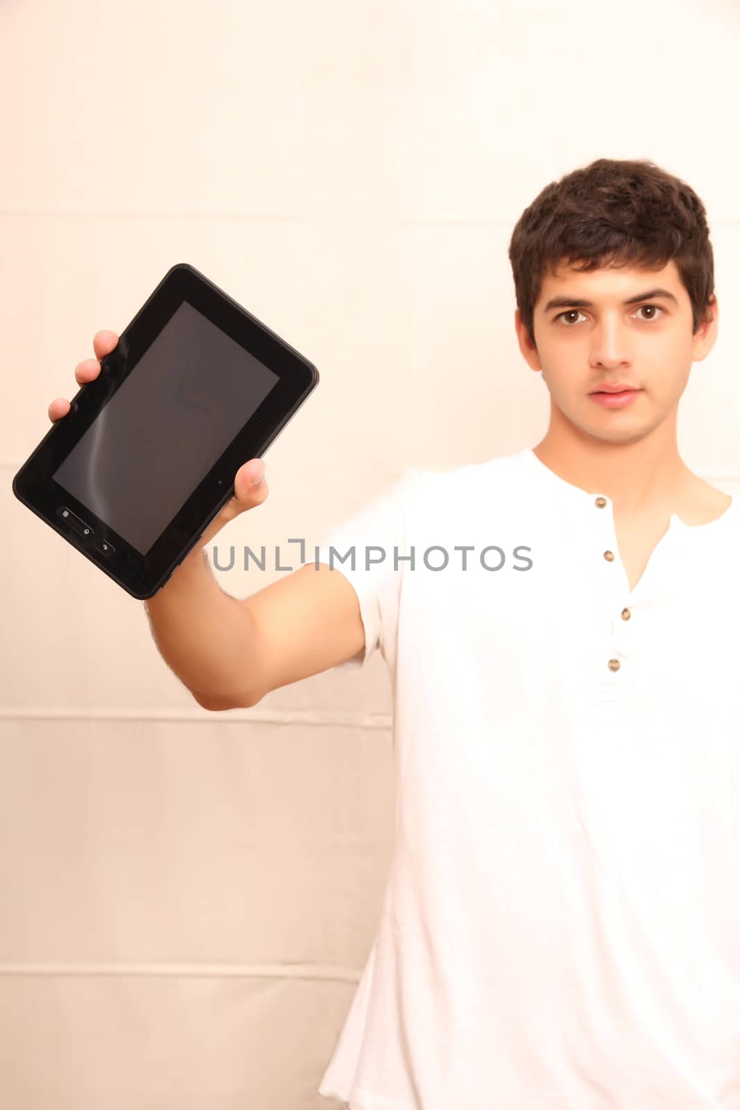 A young, latin man with a Tablet PC, tablet pc in focus
