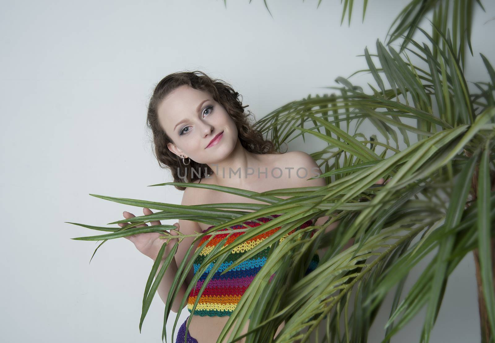 woman in a rainbow clothing under a palm tree in the Studio