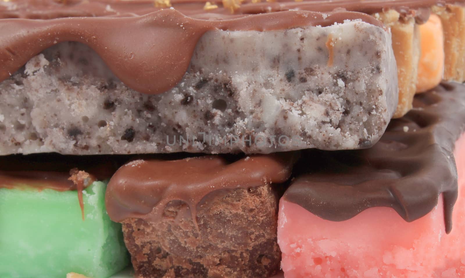Close up of fudge bar pile in different colors and flavors covered in chocolate