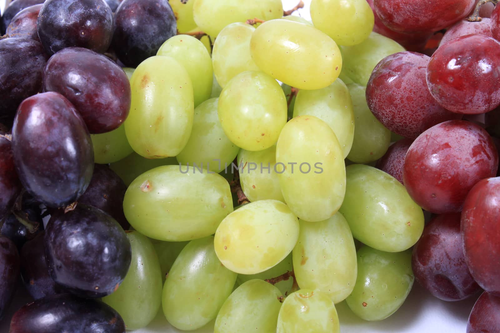 Close up of three different types of grapes in red, green and black