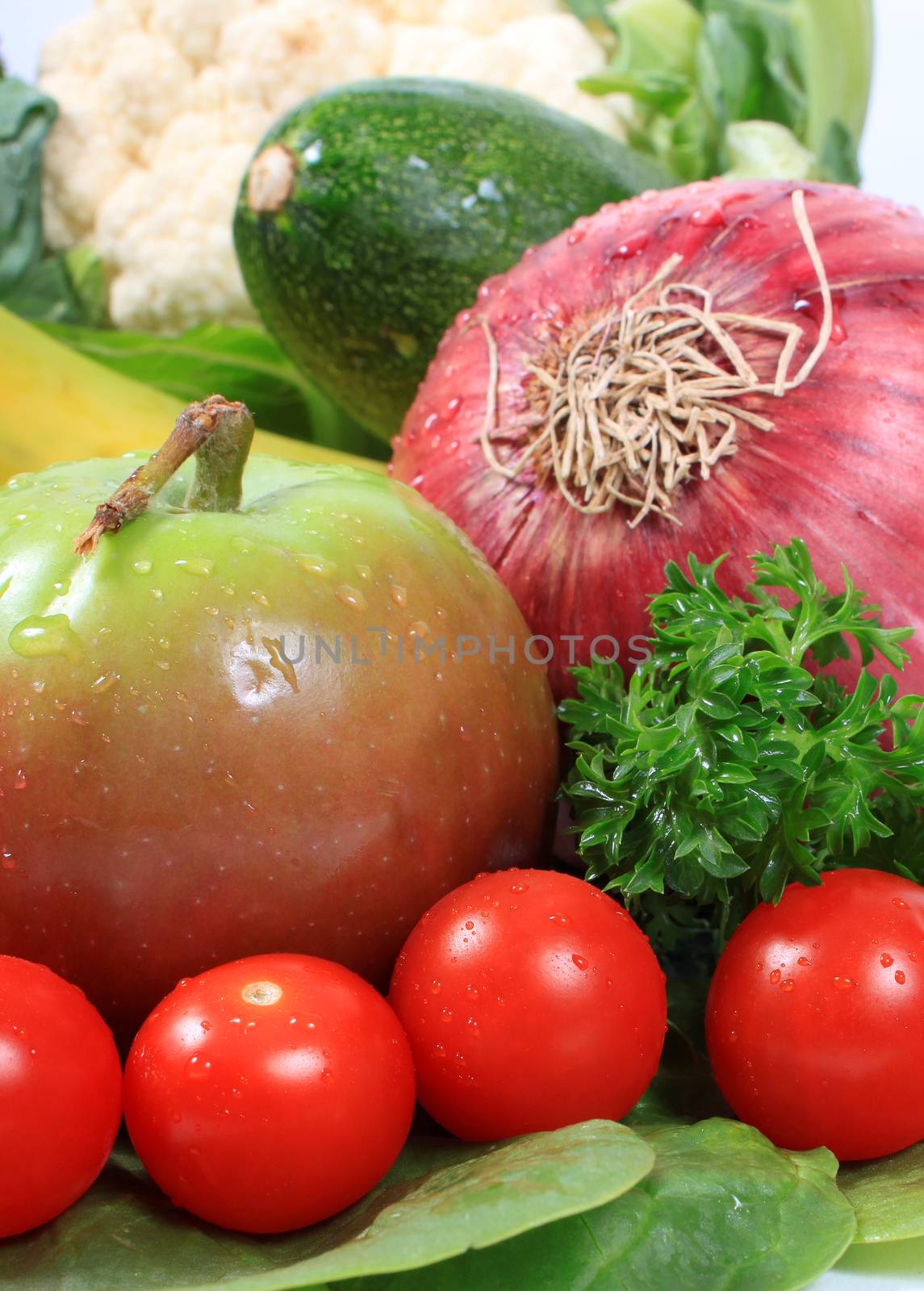 Group of wet with dew drops fruits and vegetables like grapes tomatoes, apple, red onion 